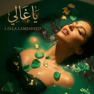 Une femme allongée dans une eau verte, les yeux fermés, entourée de pierres vertes et de feuilles d’or