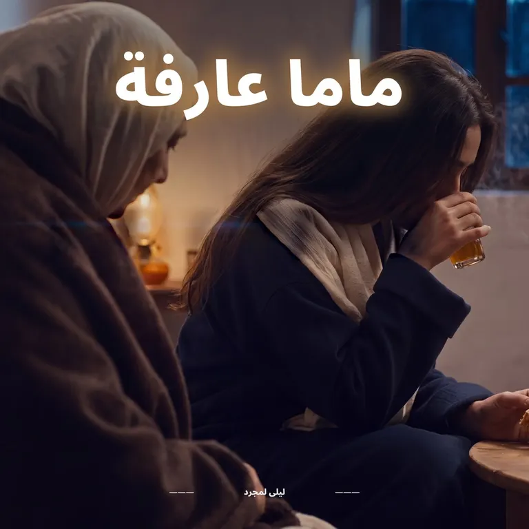 Une jeune femme triste boit un verre de thé ; sa mère, assise à côté, la regarde